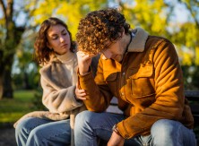 A woman talks with a man who looks frustrated. 