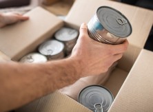 Person putting canned food in a box