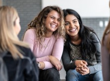Two young women laughing together.