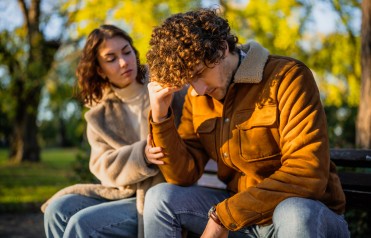 A woman talks with a man who looks frustrated. 