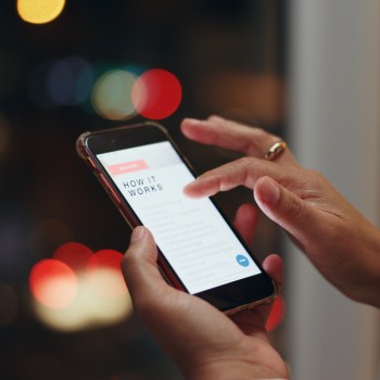Someone scrolls through a webpage titled "How It Works" on a phone screen.