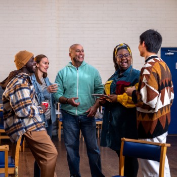 A group of people meet in a community centre.