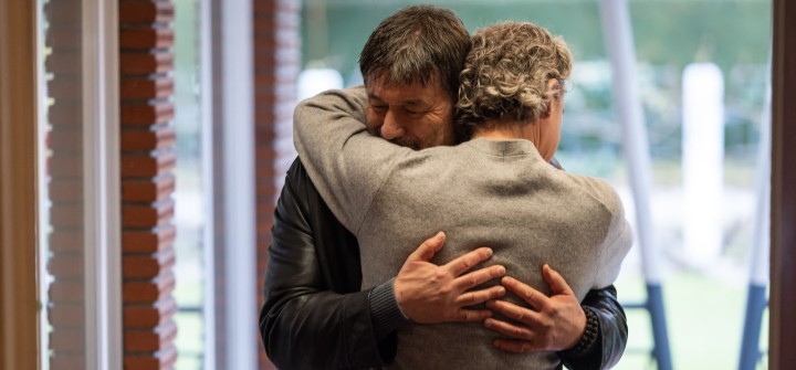 Two men hugging.