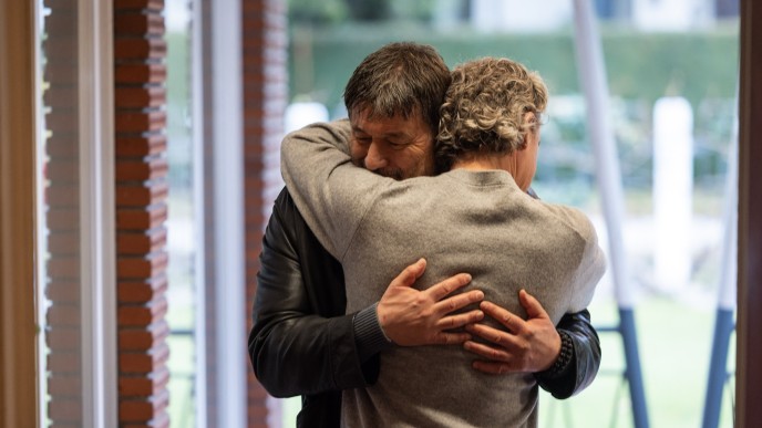 Two men hugging.