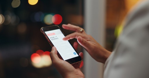 Someone scrolls through a webpage titled "How It Works" on a phone screen.