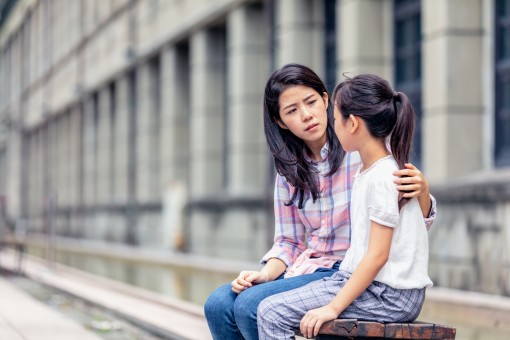 A girl and woman talk together. 