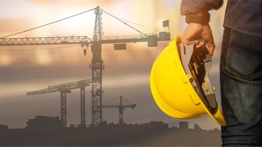 A person's hand holding a hard hat.