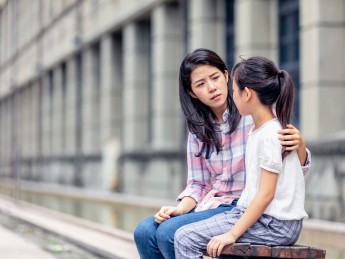 A girl and woman talk together. 