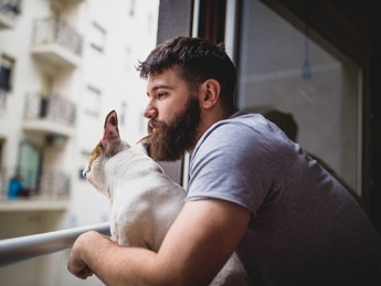 Man looks out window pensively