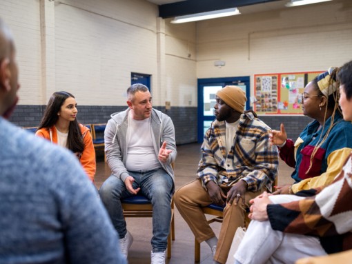 A group of people sit in a circle and talk.