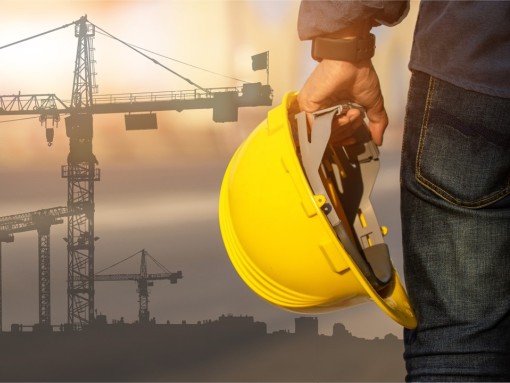 A person's hand holding a hard hat.