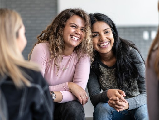 Two young women laughing together.